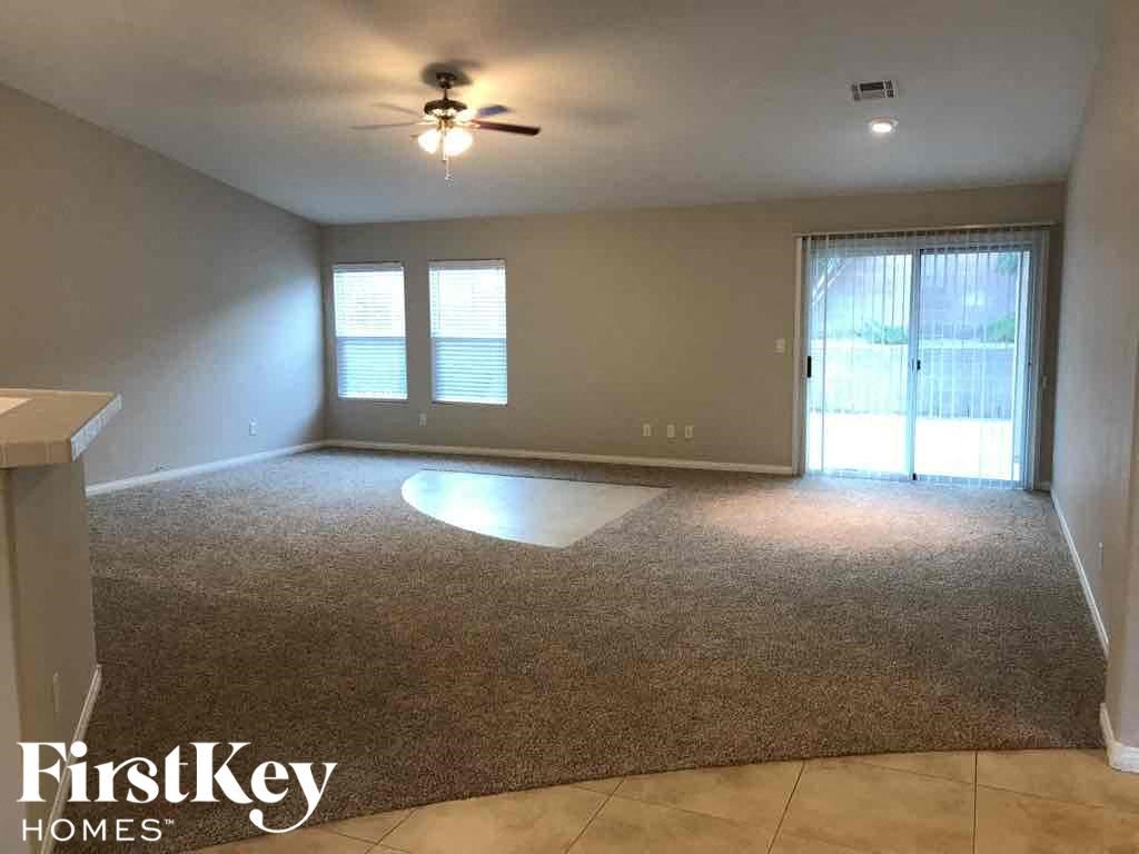 an empty living room with a ceiling fan