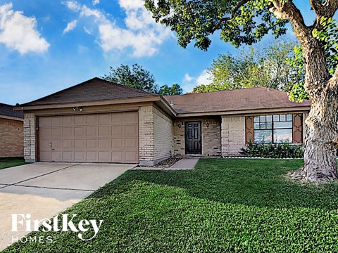 a single story home with a garage and a tree