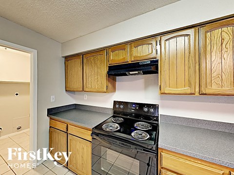a kitchen with wooden cabinets and a black stove and oven