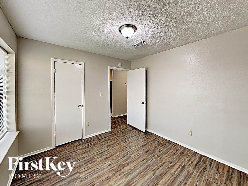 a living room with wood flooring and white walls and doors