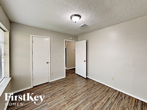 a living room with wood flooring and white walls and doors