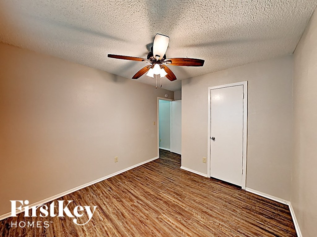 a living room with a ceiling fan and a door to a closet