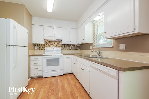 A kitchen with white appliances and cabinets.