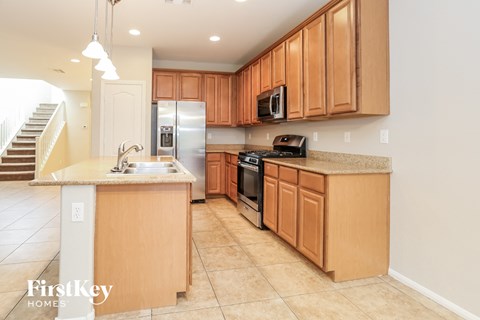 A kitchen with wooden cabinets and a stainless steel refrigerator.