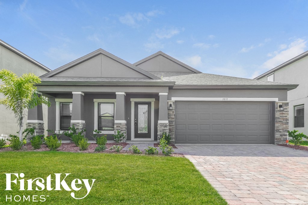 a house with a driveway and lawn in front of it