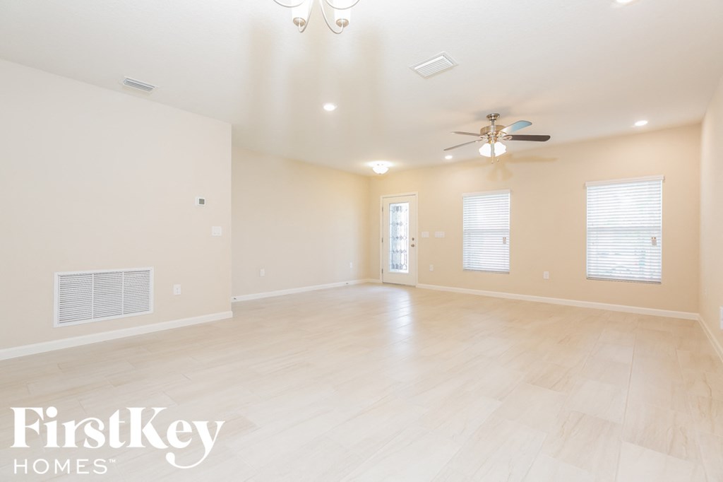 the spacious living room is open to the dining room and kitchen