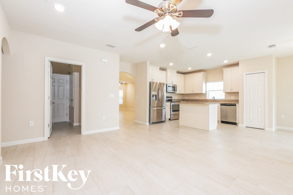 an open kitchen and living room with a ceiling fan