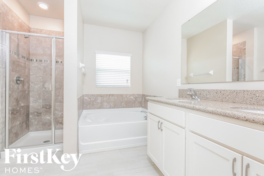 a white bathroom with a tub and a shower and a sink