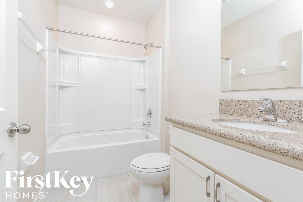 a bathroom with a toilet and a shower and a sink