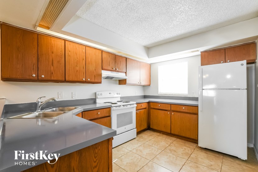 A kitchen with wooden cabinets and a white refrigerator.