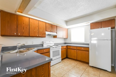 A kitchen with wooden cabinets and a white refrigerator.