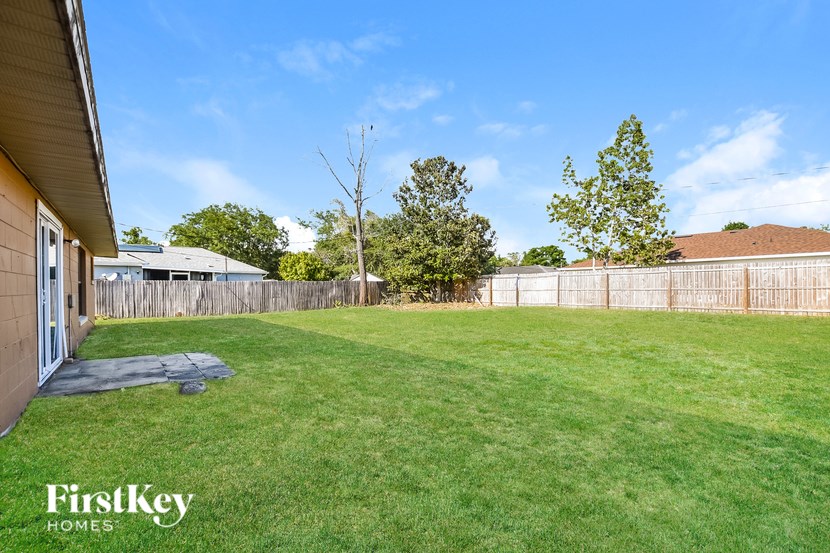 A backyard with a fence and trees.