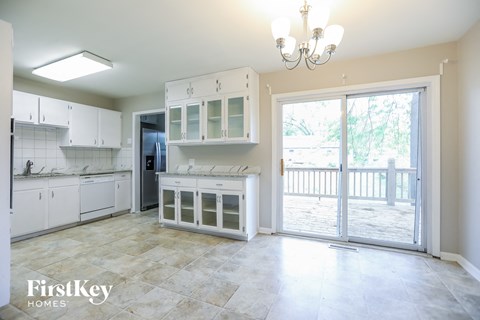 A kitchen with white cabinets and a tiled floor.