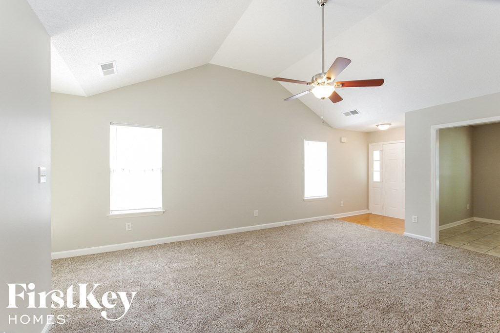 a empty living room with a ceiling fan