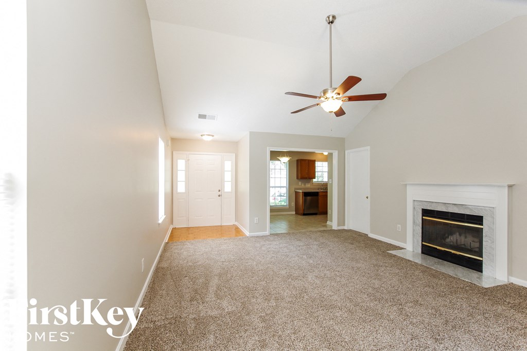 a living room with a fireplace and a ceiling fan
