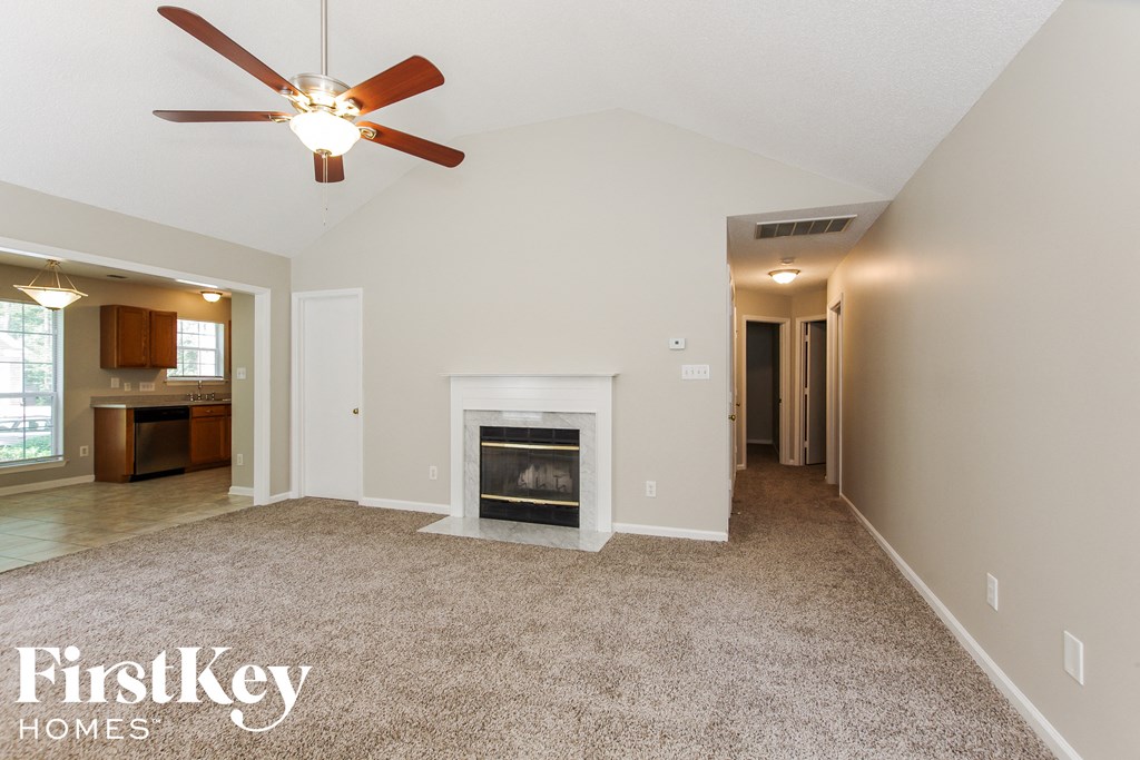 a living room with a fireplace and a ceiling fan