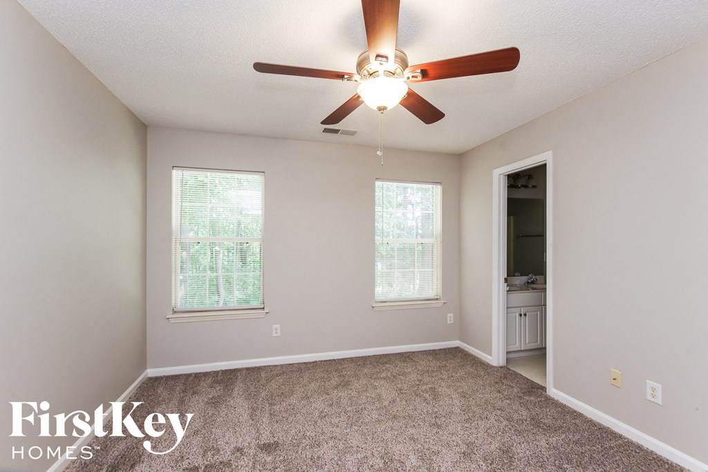 the master bedroom has a carpeted floor and a ceiling fan