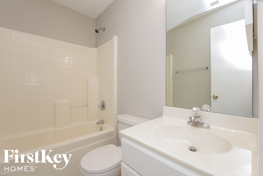 a white bathroom with a white sink and a tub and a toilet