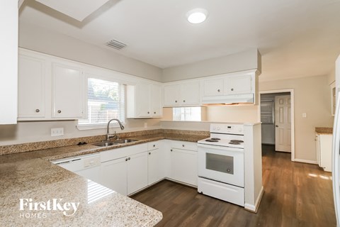 a kitchen with white cabinets and a counter top