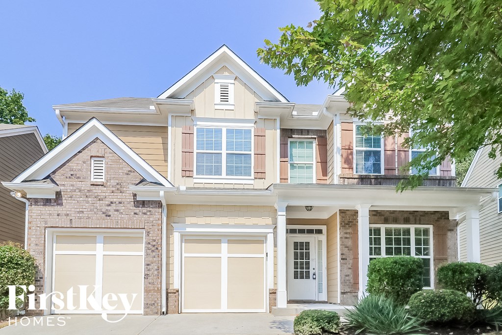 A two-story house with a garage is showcased in the image.