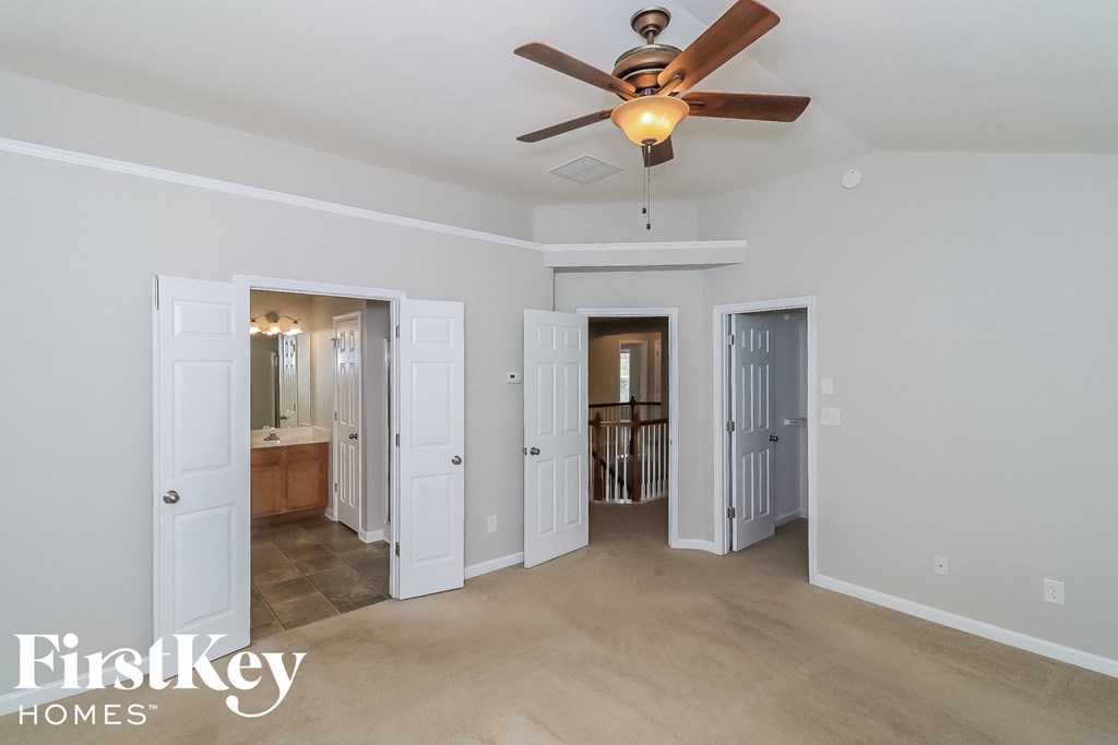 A spacious room with a ceiling fan and a light fixture, and a FirstKey Homes logo.