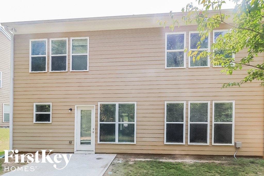 A house with a brown siding and a white door is for sale.