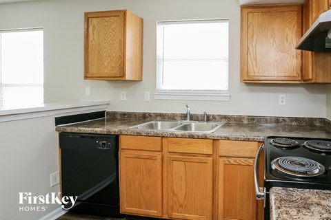 A kitchen with wooden cabinets and a black stove top.