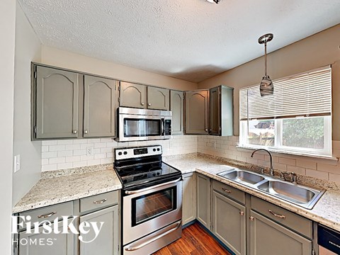 A kitchen with a stove top oven and a microwave.