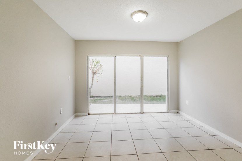 an empty living room with sliding glass doors to a patio
