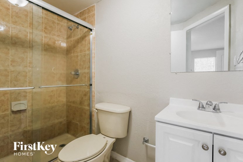 a bathroom with a shower and a toilet and a sink