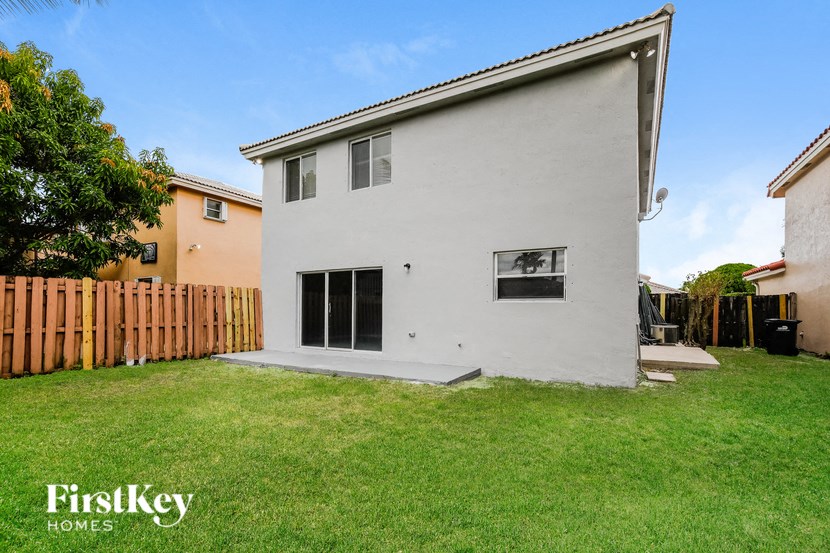 a white house with a yard and a wooden fence