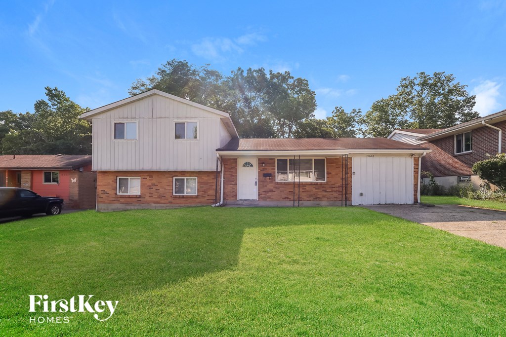 A house with a garage and a car parked in front.