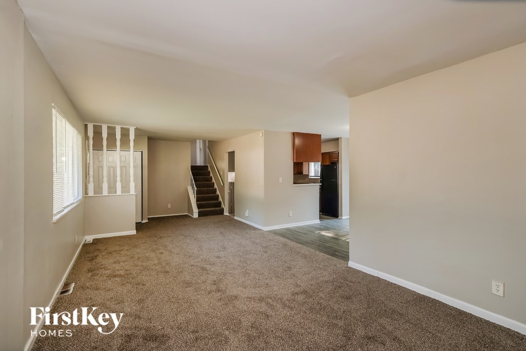 A spacious room with a staircase leading to the upper level.
