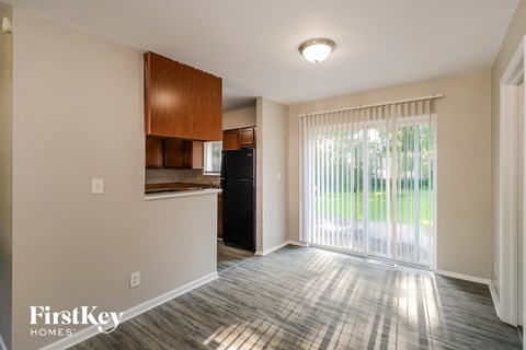 A room with a wooden cabinet and a black fridge.