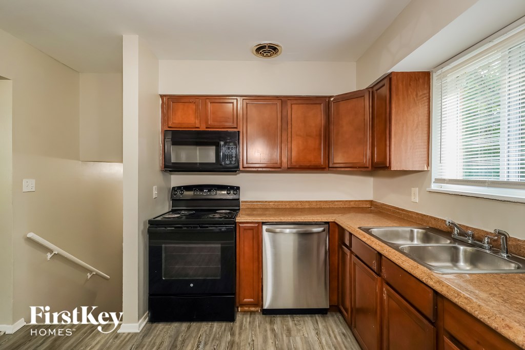A kitchen with wooden cabinets and a stainless steel dishwasher.