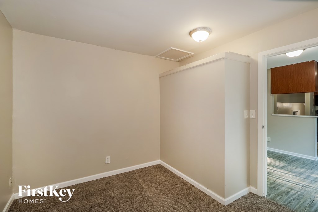 A room with a carpeted floor and a doorway leading to another room.