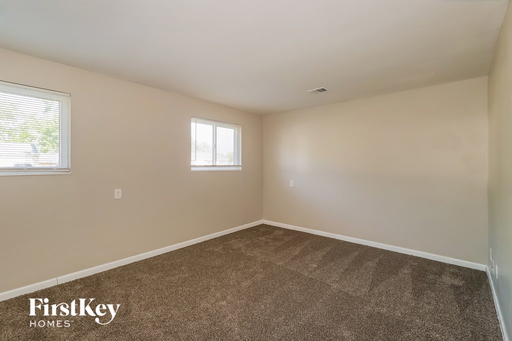 A room with a carpeted floor and a window.