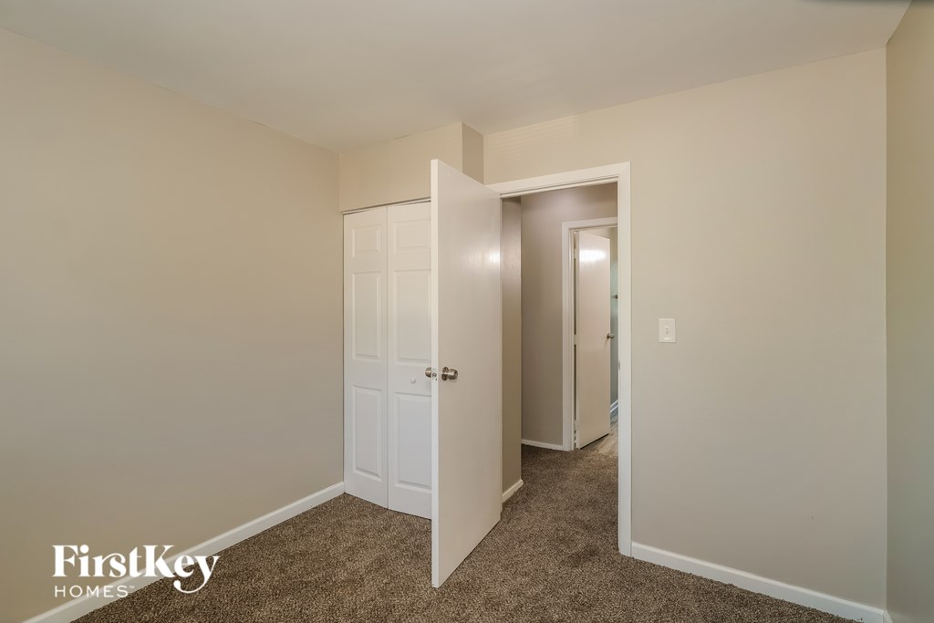 A room with a carpeted floor and a white door.