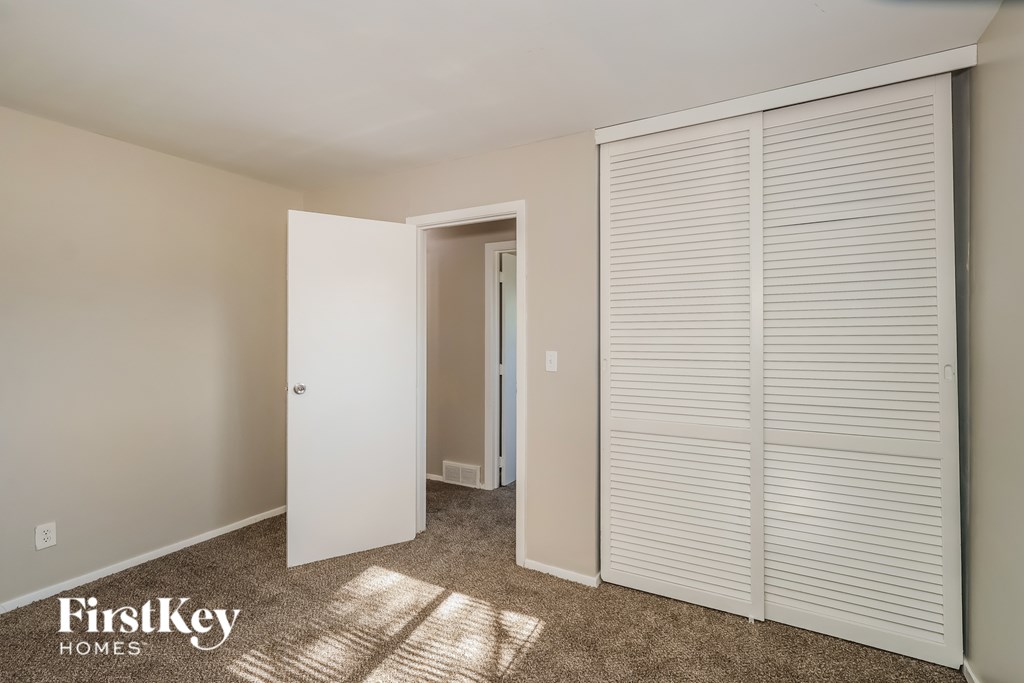 A room with a white door and a white closet with a FirstKey Homes logo.