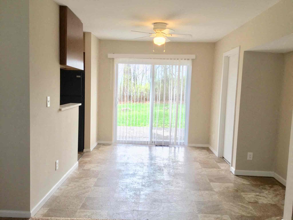 A spacious room with a tiled floor and a ceiling fan.