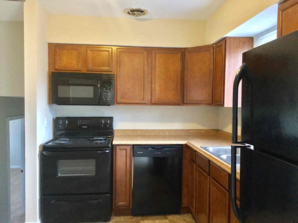 A black stove and oven in a kitchen with wooden cabinets.
