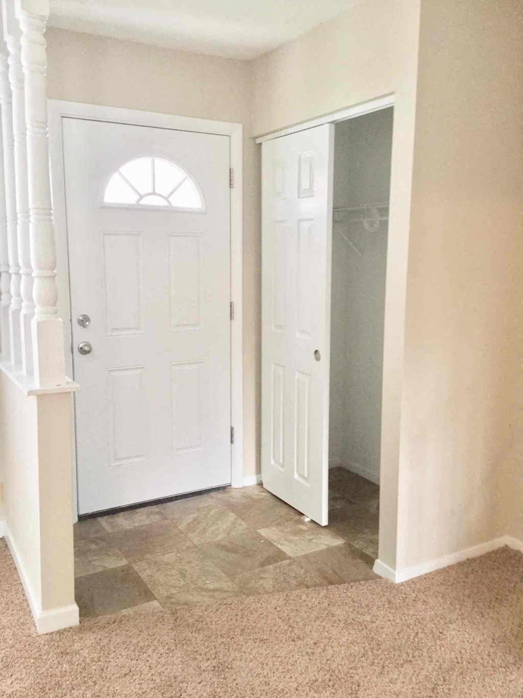 A white door with a window in the middle is in a hallway.