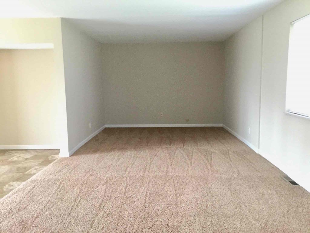 A room with a carpeted floor and white walls.