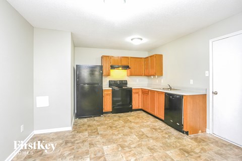 A kitchen with black appliances and wooden cabinets.