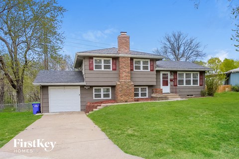 a brown and with a garage and a lawn