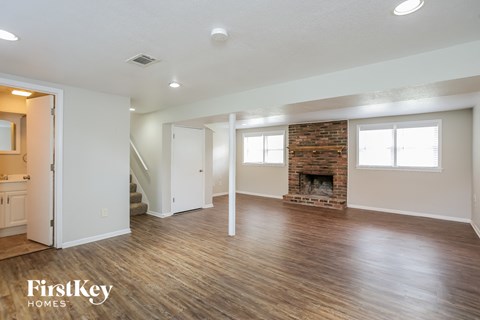 the living room with wood floors and a fireplace