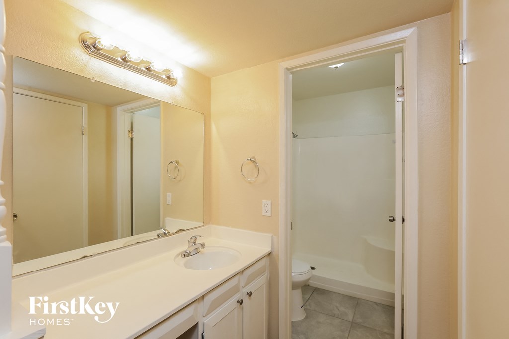 a bathroom with a large mirror and a sink and a toilet