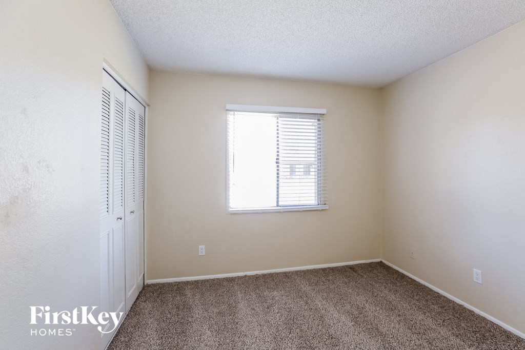 a bedroom with carpet and a window and a closet