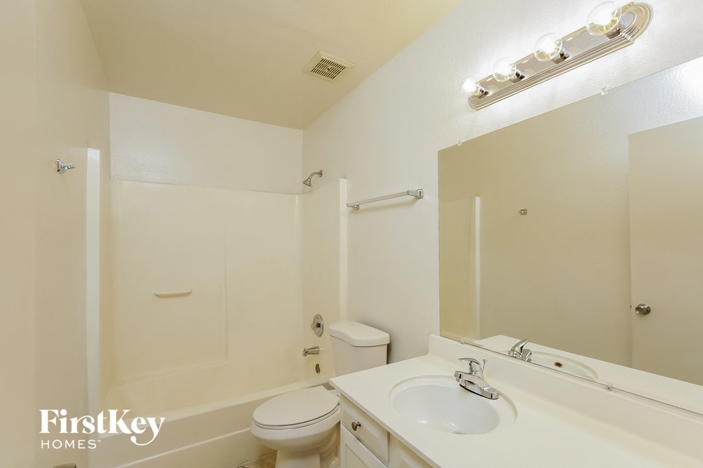 a bathroom with a sink toilet and a mirror