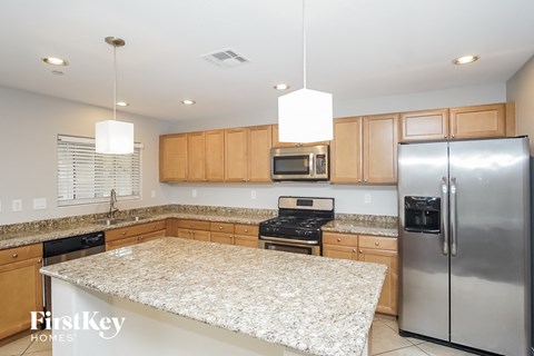 A kitchen with a granite countertop and stainless steel appliances.